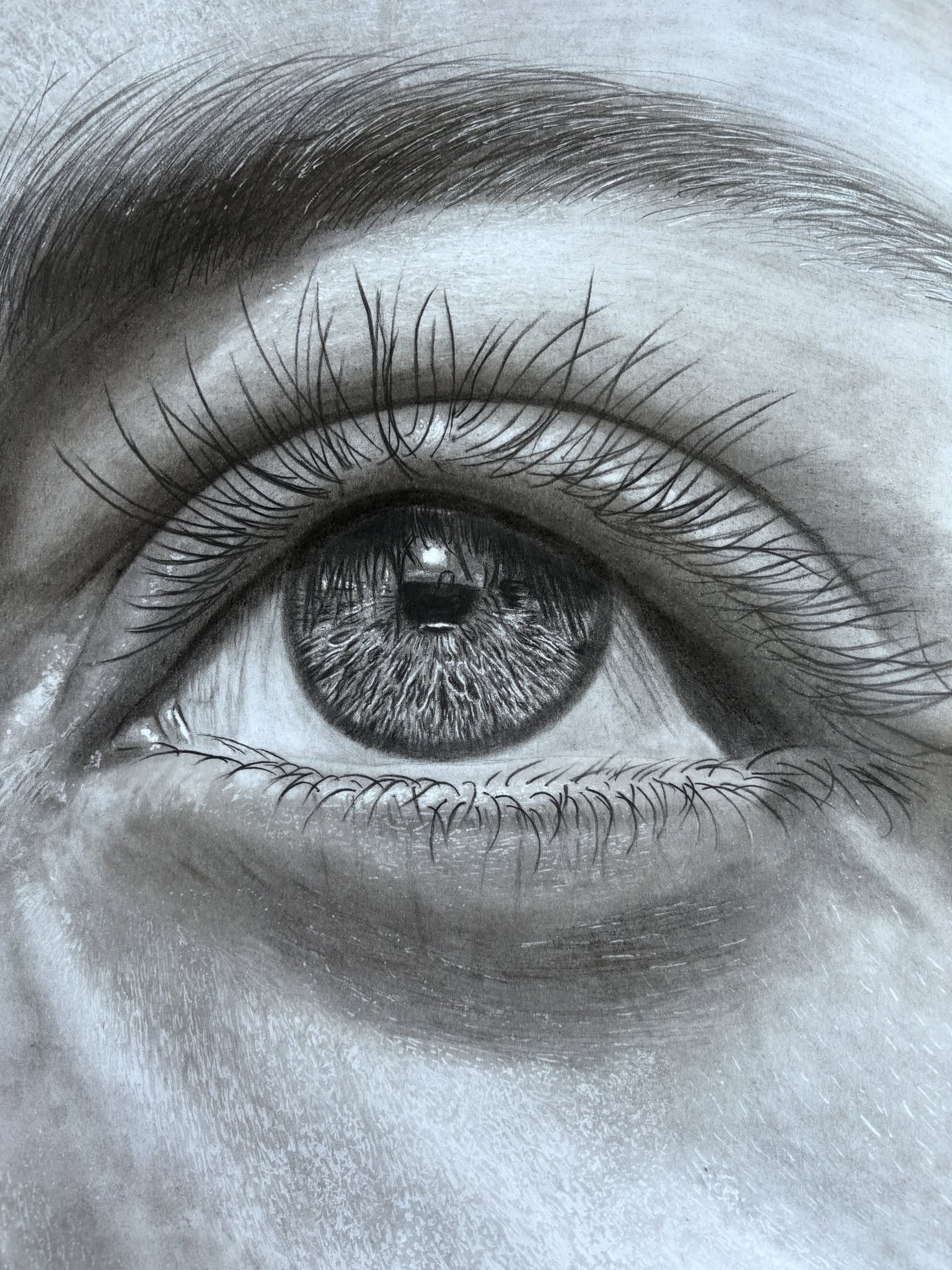 Completed hyper-realistic charcoal drawing of an eye by Rob Greenwood